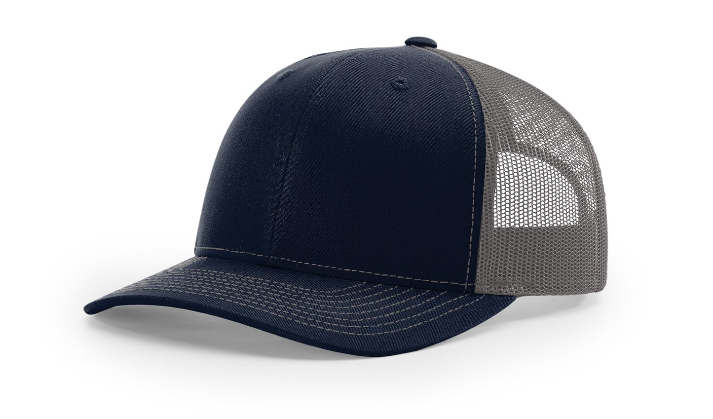 Richardson 112 Trucker Hat in Navy and Charcoal with structured front, mesh back, pre-curved visor, and adjustable snapback closure.